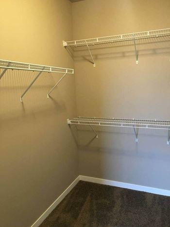 A walk in closet in a bedroom plus den unit at the abbey at stone oak in